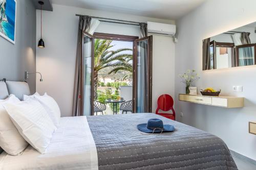 a bedroom with a bed with a hat on it at Olia Green Residence in Skopelos Town