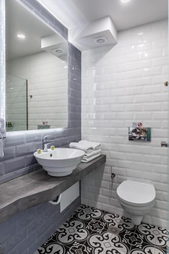 a white bathroom with a sink and a toilet at Olia Green Residence in Skopelos Town