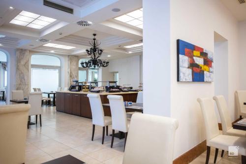 a dining room with a table and white chairs at Hotel Regina Elena 57 & Oro Bianco SPA in Rimini