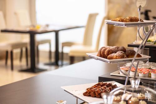 a table with three tiers of pastries on plates at Hotel Regina Elena 57 & Oro Bianco SPA in Rimini