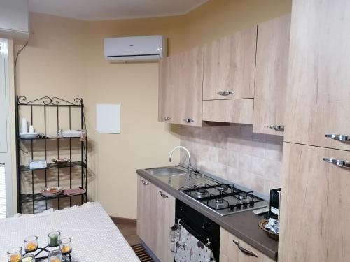 a kitchen with wooden cabinets and a stove top oven at Agave in Reggio Calabria