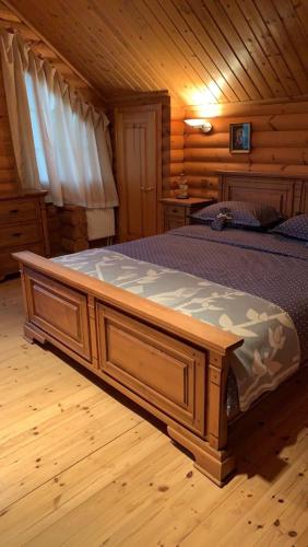 a large wooden bed in a wooden cabin at Фінський будинок для ідеального романтичного чи сімейного відпочинку in Makovishche