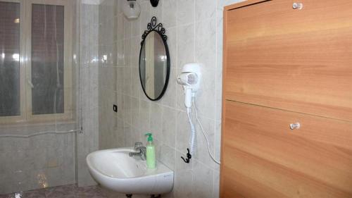 uma casa de banho com um lavatório e um secador de cabelo na parede em RIPARRUCCI nel Residence Praetorium Maiella em Pretoro