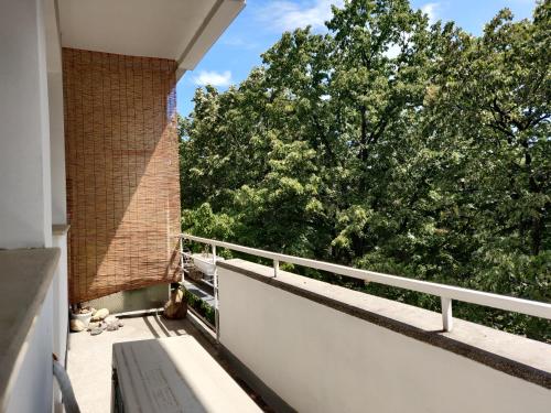 a balcony of a building with trees in the background at White Apartment in Kazanlŭk