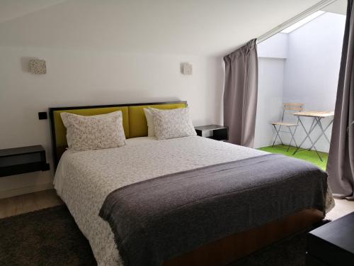 a bed in a bedroom with a white bedspread at Porto Suites do Marquês in Porto