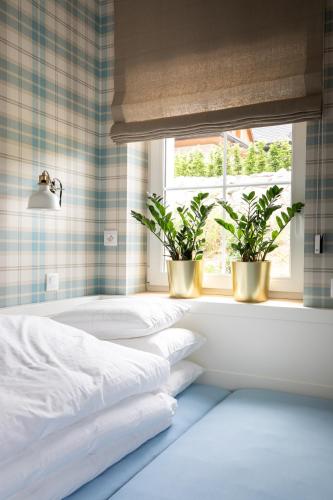 a bedroom with two potted plants in a window at VRÁTNA Apartmány Stoh B1 in Terchová