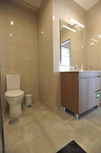 een badkamer met een toilet, een wastafel en een spiegel bij Lagos Central Apartments Ap 9 in Lagos