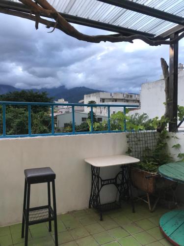 a table and two stools on a balcony at 池上5159懷舊民宿 請勿用阿勾達訂房 in Chishang
