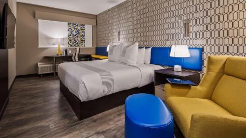 um quarto de hotel com uma cama e um sofá em GLō Best Western Tulsa-Catoosa East Route 66 em Catoosa
