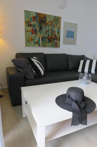 a living room with a black couch and a white coffee table at Casa Arrigo - Splendido bungalow centrale con grande terrazza e vista mare in Puerto del Carmen