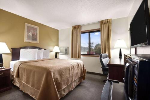 a hotel room with a bed and a window at Travelodge by Wyndham La Porte/Michigan City Area in LaPorte