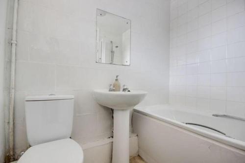 y baño con lavabo, aseo y bañera. en 6 Greville Court, en Londres