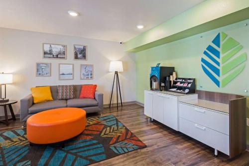 a living room with a couch and a tv in it at WoodSpring Suites Davenport Quad Cities in Davenport