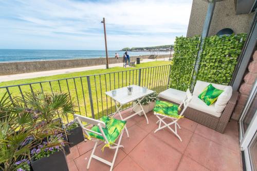 a patio with a table and chairs and the ocean at Bayview Bed and Breakfast in Stonehaven