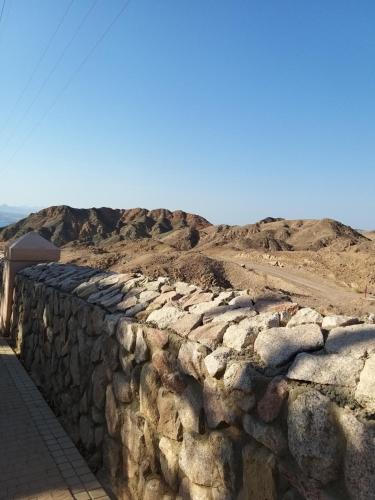 a stone wall in front of a dirt field at סטודיו 10 studio in Eilat