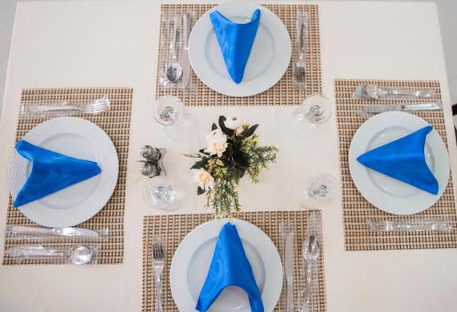 a table with blue napkins and plates with blue shoes at Jewel Port Said Hotel in Port Said