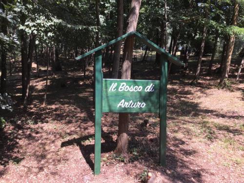 a green sign in the middle of a forest at B&B CORTE SANT'ANGELO in Passirano