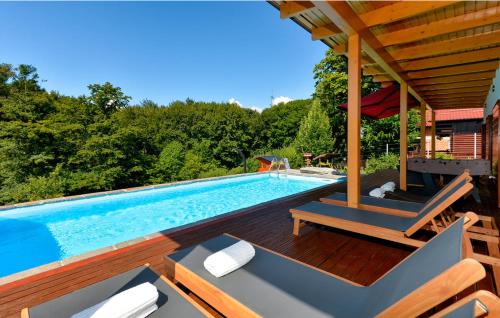 a swimming pool with a wooden deck and a swimming poolvisor at Crab's Creek Zagreb in Rakov Potok