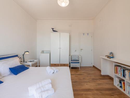 a bedroom with a white bed and a book shelf at Il Profumo del Mare GuestHouse in Cagliari