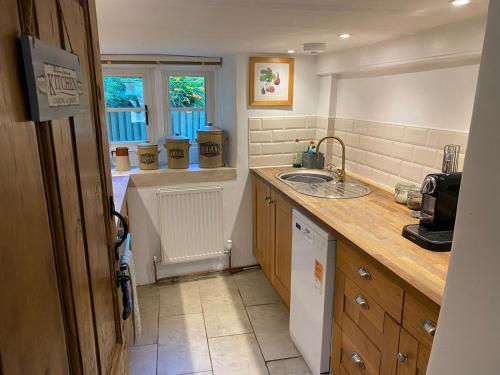 a kitchen with a sink and a counter top at Roman Cottage Colerne in Colerne