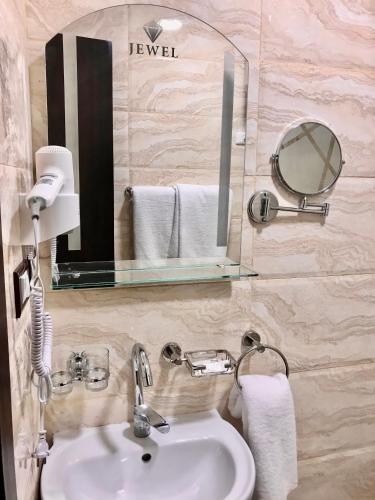 a bathroom with a sink and a mirror and towels at Jewel Port Said Hotel in Port Said
