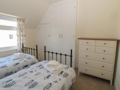 a bedroom with two twin beds and a dresser at Hazonleigh in Seahouses