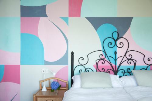 a bedroom with a bed and a colorful wall at CHARMING MOMENT di Villa Porta - Residenza Leonardo in Luino