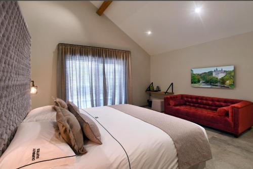 una camera con un letto e un divano rosso di DURBUY SUITES a Durbuy