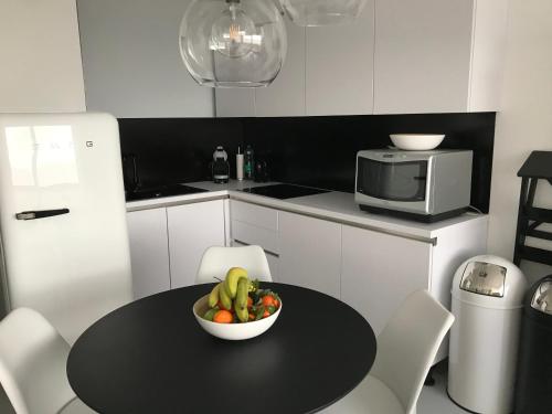 a kitchen with a table with a bowl of fruit on it at Malibu Beach 9C in Blankenberge