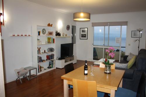a living room with a table and a couch at Vista Mar in Caniço