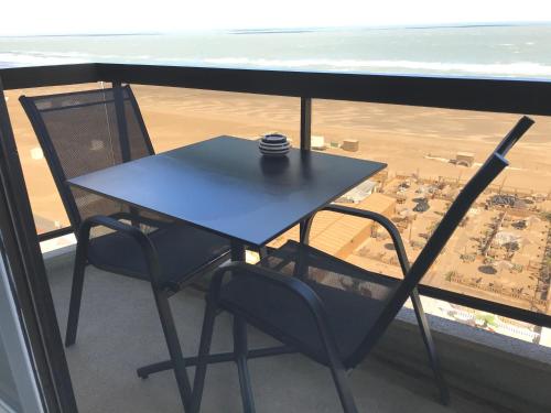 a table and chairs on a balcony with a view of a city at Malibu Beach 9C in Blankenberge
