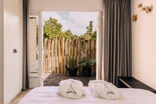 ein Schlafzimmer mit zwei Handtüchern auf dem Bett in der Unterkunft The Pine Tree House in Zandvoort