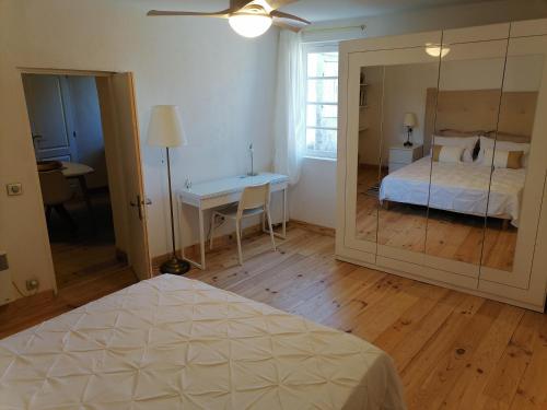 a bedroom with a bed and a table and a mirror at Chez Laurence 2 pieces 43 m2 à 30 minutes de la mer in Pignans