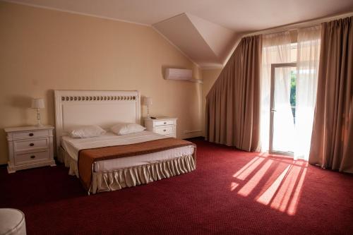 a bedroom with a bed and a large window at AZIMUT Hotel Nalchik in Nalchik
