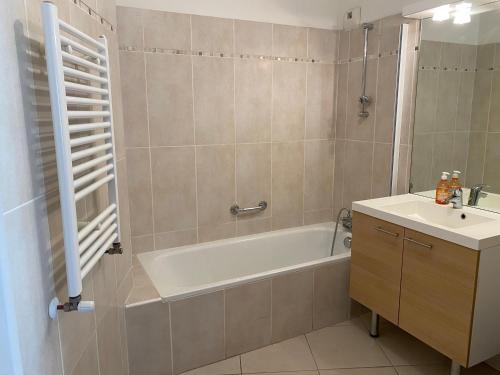 une salle de bain avec une baignoire et un lavabo dans l'établissement La Villa Fréjus-Plage, à Fréjus