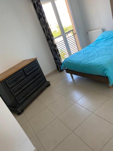 une chambre avec un lit et une grande fenêtre dans l'établissement La Villa Fréjus-Plage, à Fréjus