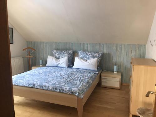 a bedroom with a bed with blue and white pillows at Ferienwohnung Größing in Finkenstein
