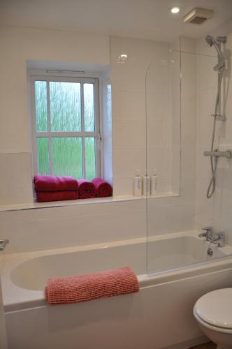 a white bathroom with a tub and a window at Modern Home just off Glastonbury High Street in Glastonbury