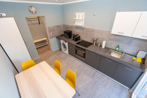 a kitchen with a table and yellow chairs at Bremerhavener Suite 2 in Bremerhaven