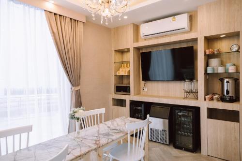 a dining room with a table and a tv at The Cape Hotel in Udon Thani