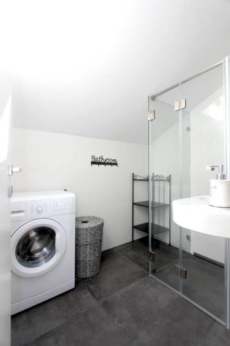 a bathroom with a washing machine and a sink at Beachfront Apartment. 2xAC & BIKES in Postira