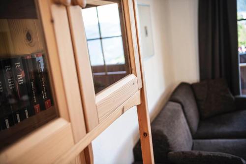 a room with a mirror and a couch and a chair at Chalet Grumer Suites&Spa in Soprabolzano
