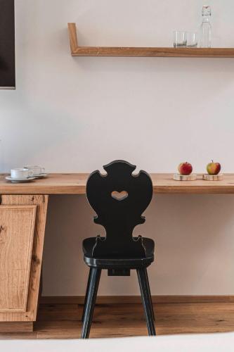 a black chair sitting in front of a desk at Chalet Grumer Suites&Spa in Soprabolzano