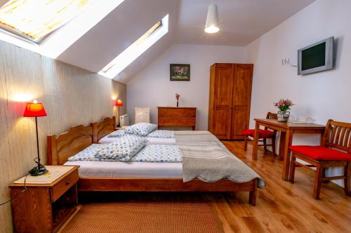 a bedroom with a bed and a table and a chair at Casa Adalmo in Sighişoara
