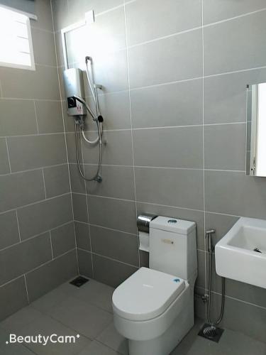 a bathroom with a toilet and a sink at FangFei Homestay in Seremban