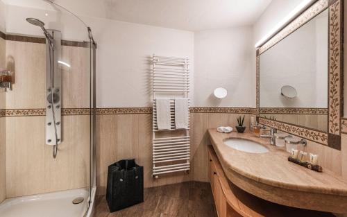 a bathroom with a sink and a shower at Chalet Grumer Suites&Spa in Soprabolzano