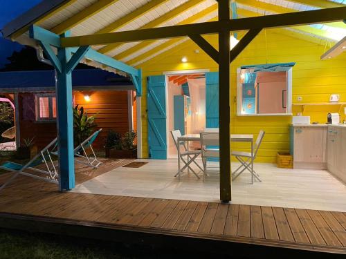 Casa con terraza con mesa y sillas en Les Cauris de l'Anse, en Sainte-Anne