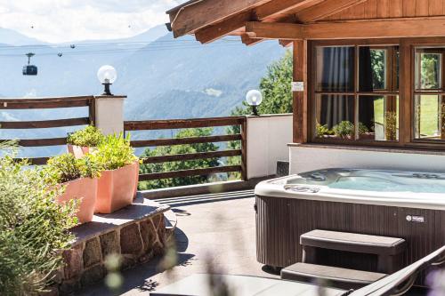 a hot tub on a patio with a view of the mountains at Chalet Grumer Suites&Spa in Soprabolzano