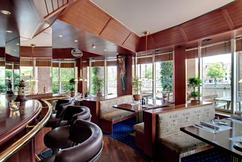 a restaurant with chairs and tables and windows at Radisson Blu Senator Hotel, Lübeck in Lübeck