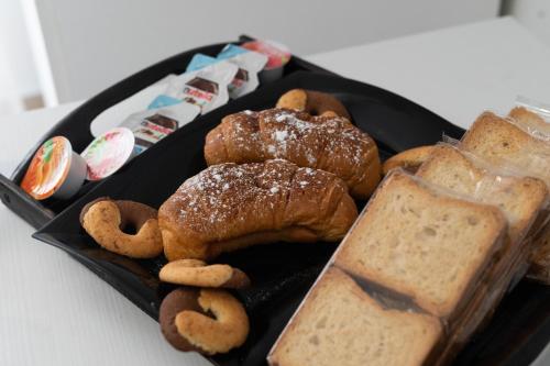 un piatto nero con dolci e pane su un tavolo di DIMORA ROSSA a Sottomarina